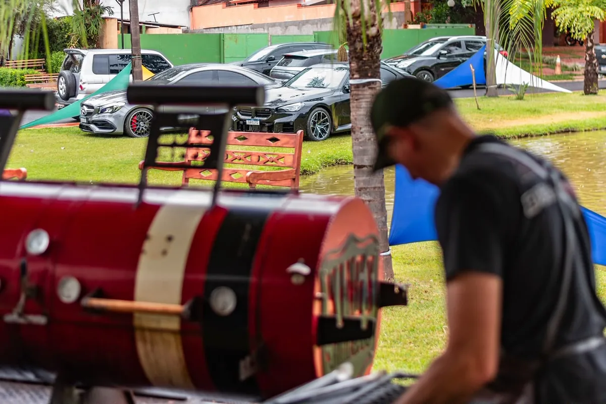 Churrasqueira e carros ao fundo